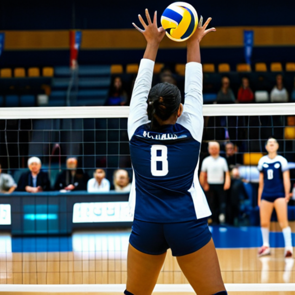 A professional female indoor volleyball player in a modest, dark blue and white team uniform, including athletic shorts, a jersey, and knee pads, mid-action, powerfully spiking a volleyball over the net. She is captured in a dynamic, athletic pose on a polished wooden court in a brightly lit indoor sports arena. The background shows blurred spectators in the stands, creating a sense of energy and scale. Fully clothed, appropriate attire, safe for work, professional dress, perfect anatomy, correct proportions, natural pose, well-formed hands, proper finger count, natural body proportions, high-quality sports photography.