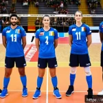 배구 전술 핸드북 - A dynamic volleyball team huddled on an indoor court in Italy, focusing on strategy discussion. Play...